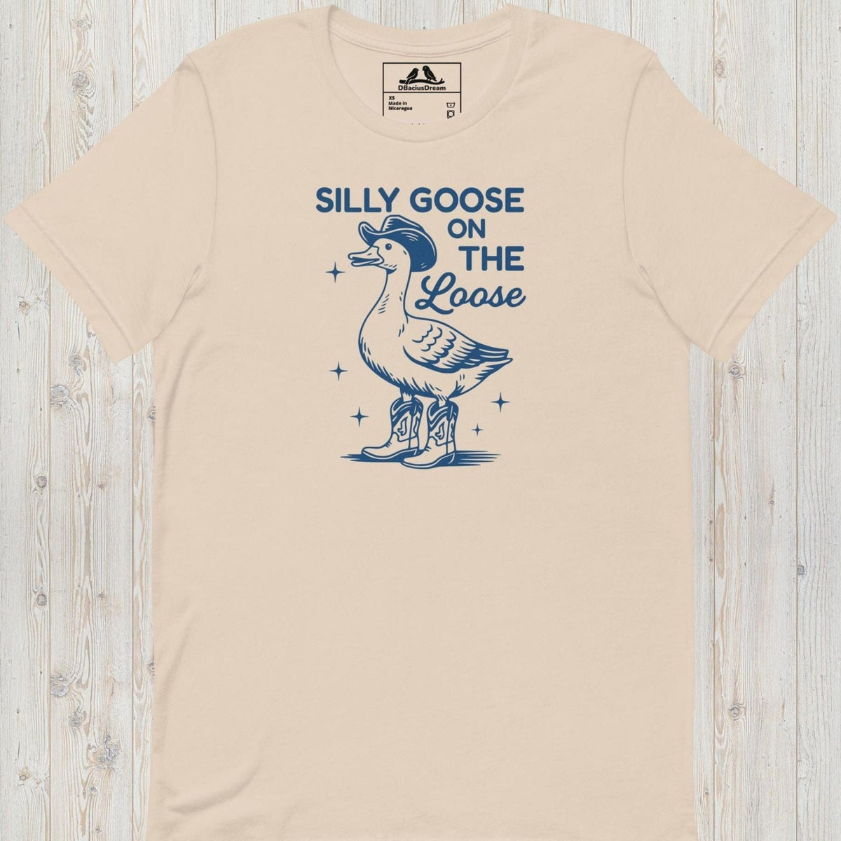 Light beige silly goose on the loose t-shirt with a playful goose illustration and the humorous quote "Silly Goose On The Loose"