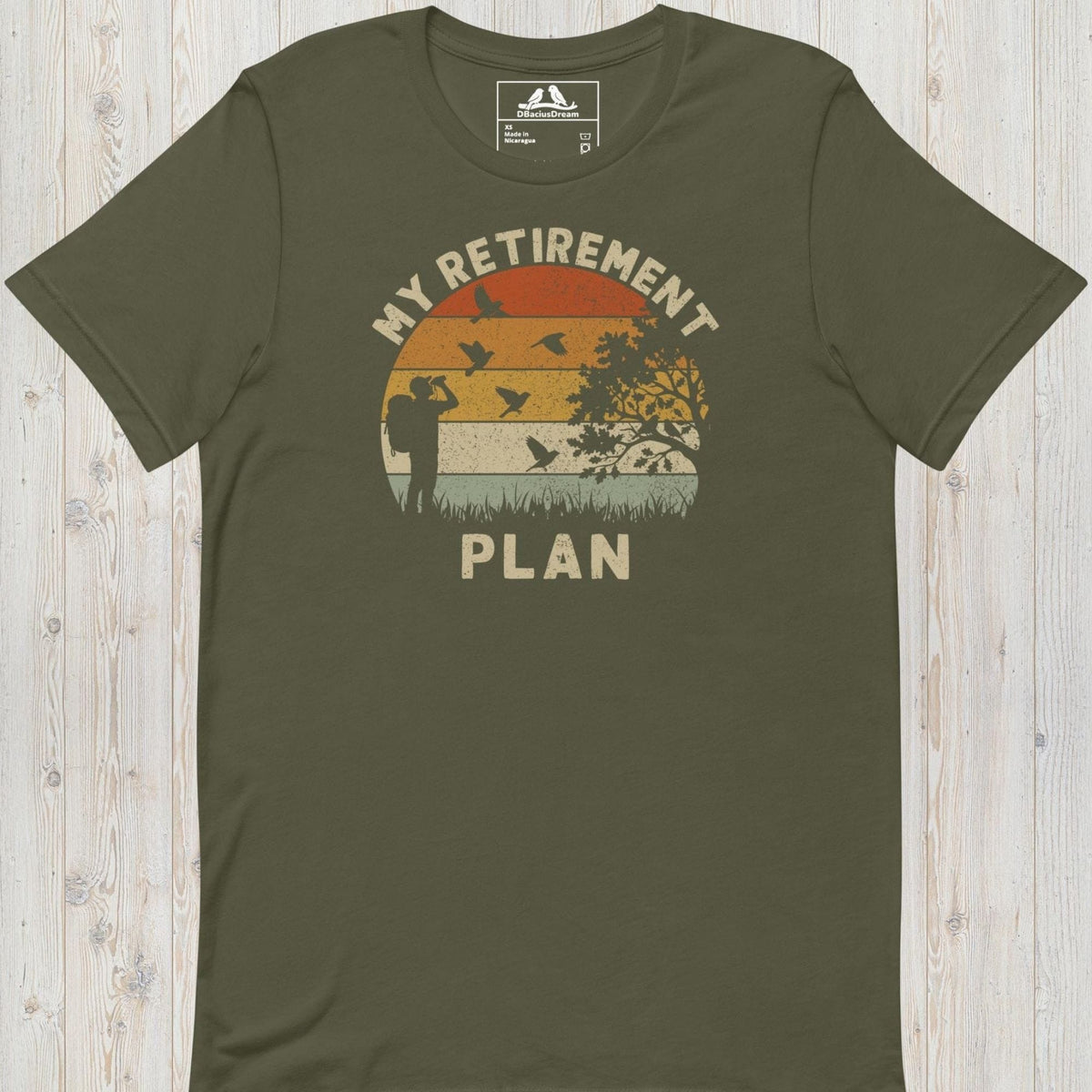 Olive green birding my retirement plan t-shirt with a vintage sunset graphic, a birder, and flying birds