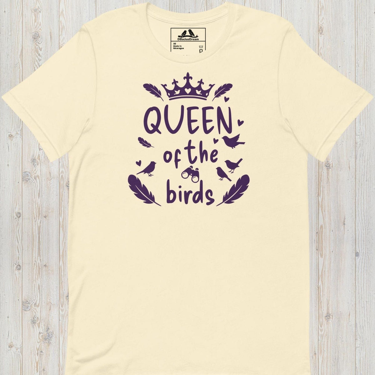 Cream queen of the birds t-shirt with a purple bird graphic, crown design and decorative bird silhouettes